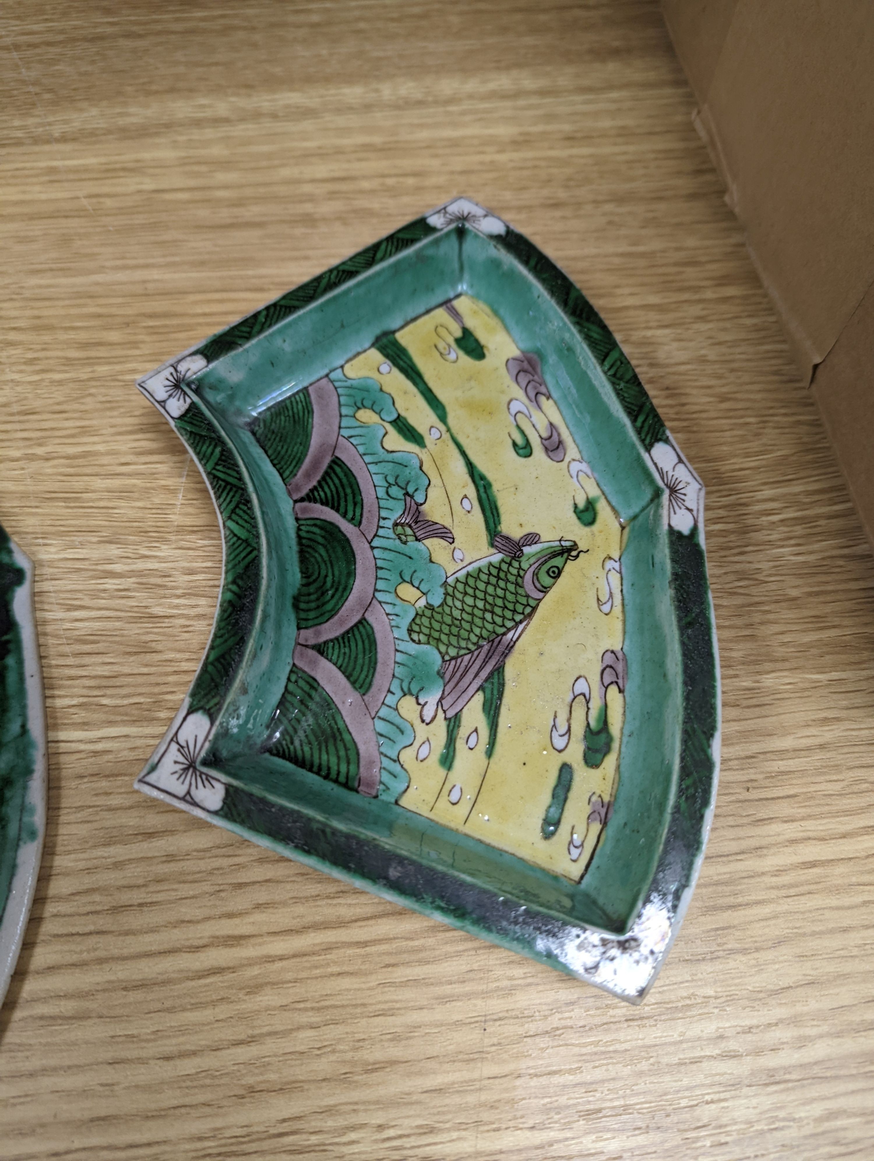A pair of Chinese famille verte biscuit fan-shaped sweetmeat dishes, Kangxi, 20 cms wide.